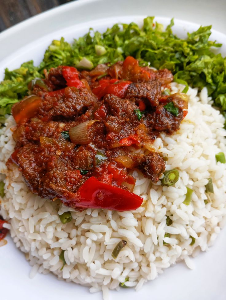 Plain rice with stew,fried chicken, and salad.